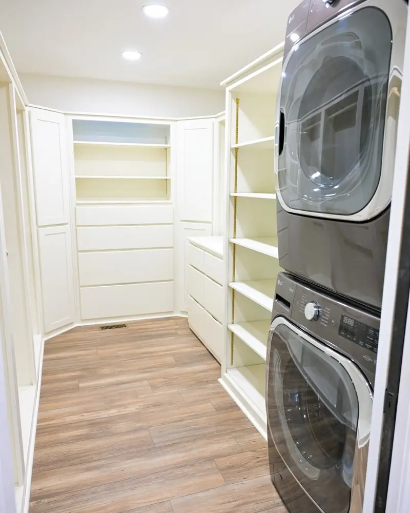 Home addition in Salisbury, MO: laundry room with stacked washer and dryer and built-in shelves
