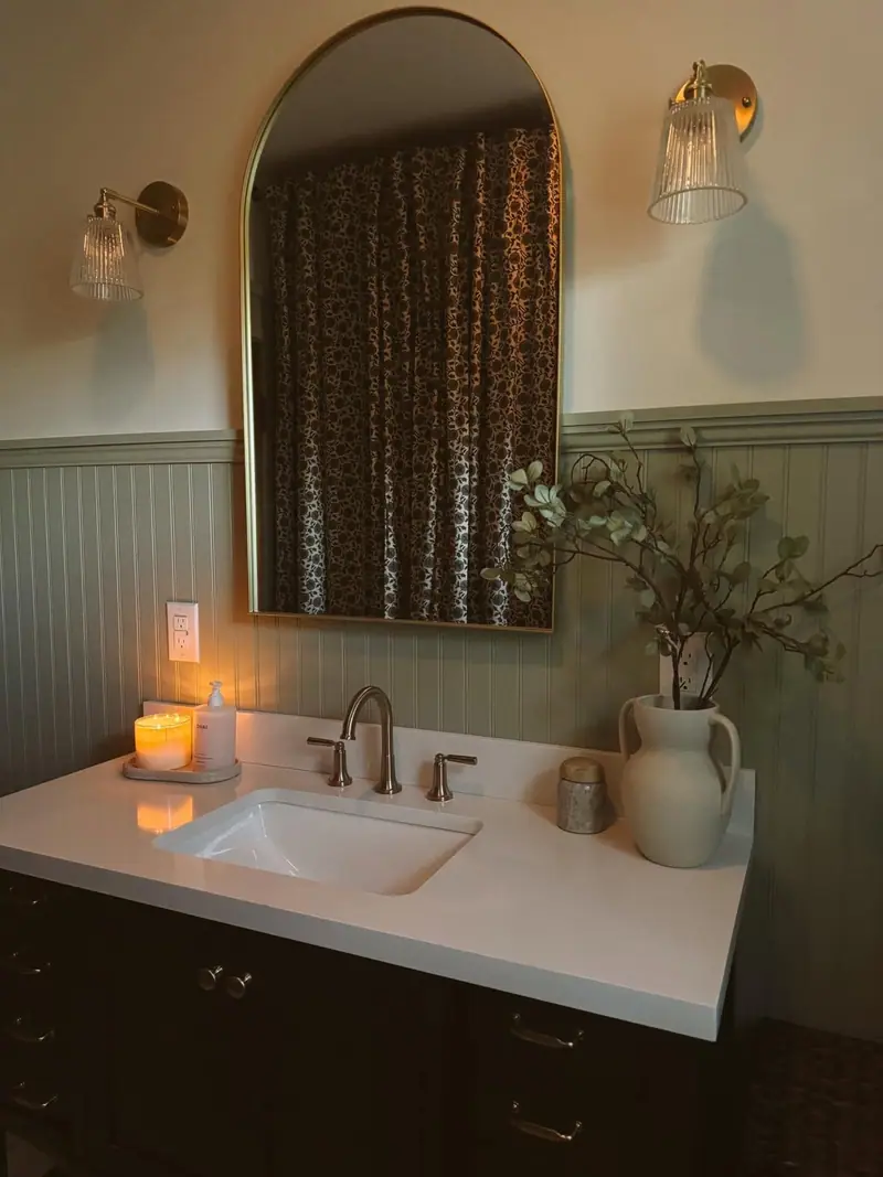 Bathroom remodel in Salisbury, MO: arched mirror, glass sconces, and quartz vanity top
