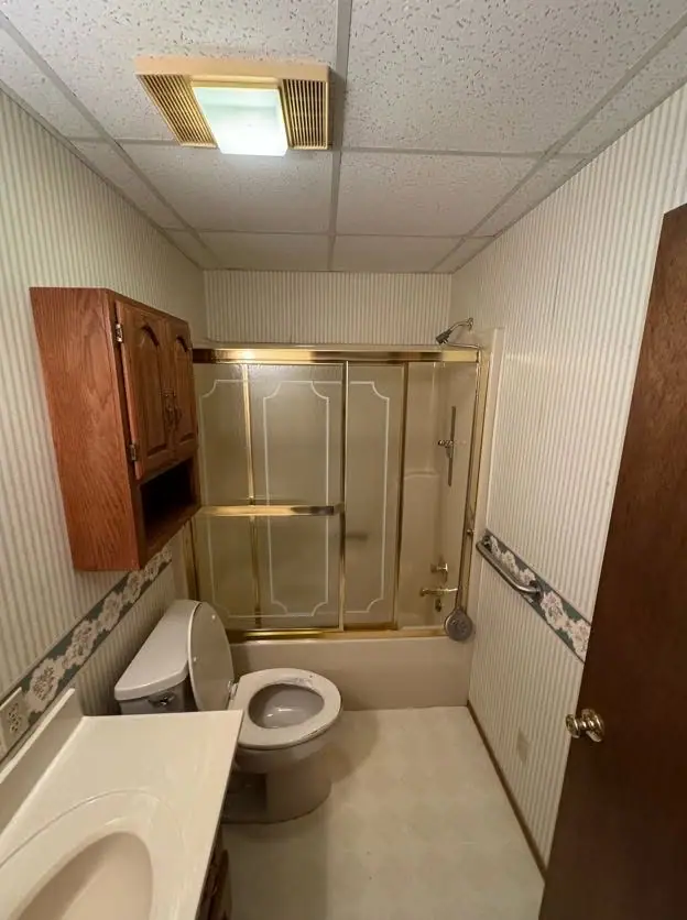 Tub-to-shower conversion in Salisbury, MO, before: tub with gold-framed glass doors