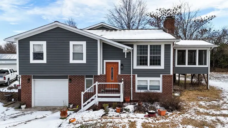 Siding replacement in Brunswick, MO, after: slate gray lap siding and white trim