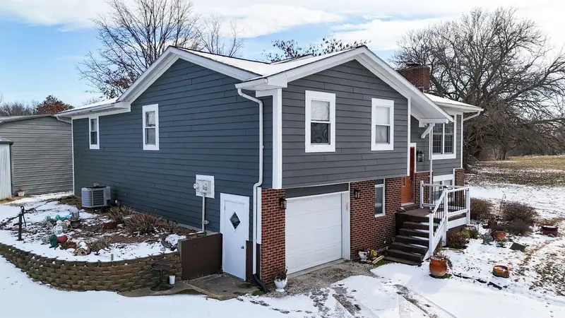 Siding replacement in Brunswick, MO: split-level home with new gray siding