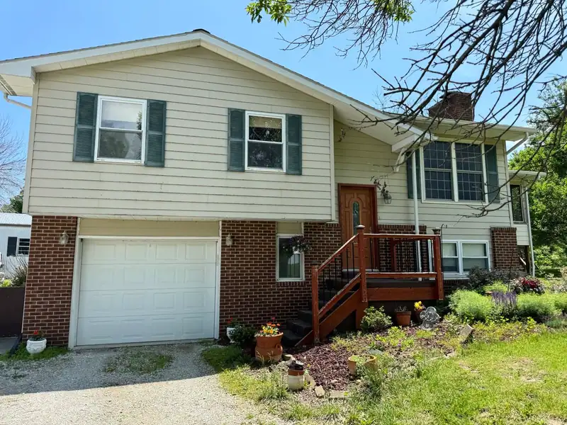 Siding replacement in Brunswick, MO, before: faded beige siding and shutters