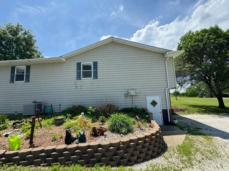 Siding replacement in Brunswick, MO, before: side of the house in beige siding