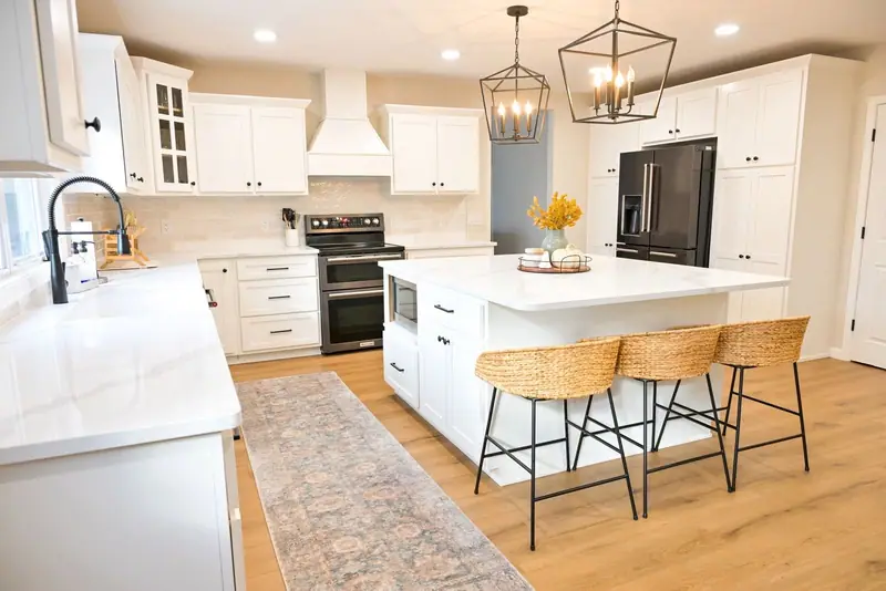 Whole-home remodel in Salisbury, MO: white kitchen with a quartz island and lantern pendant lights