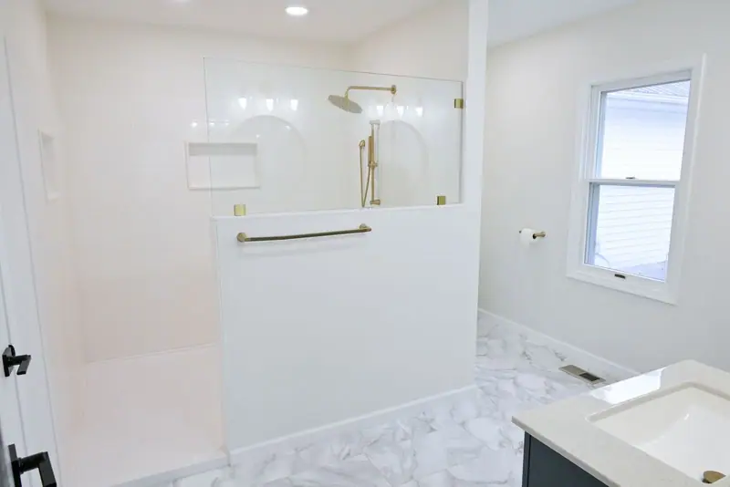 Whole-home remodel in Salisbury, MO: walk-in shower with glass panel and brass fixtures